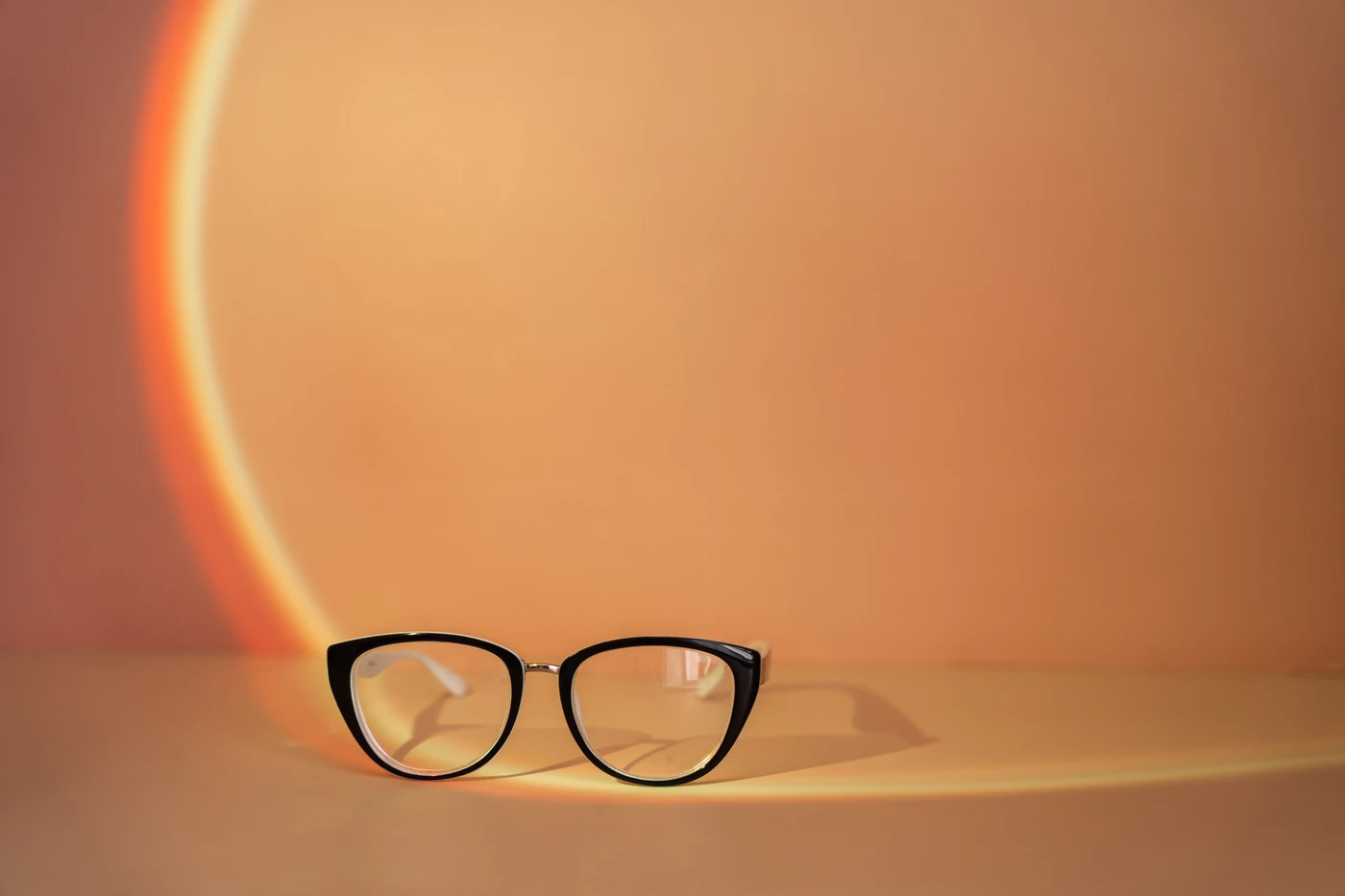 Monturas de gafas vintage exclusivas en Almería con diseño cat-eye y fondo cálido